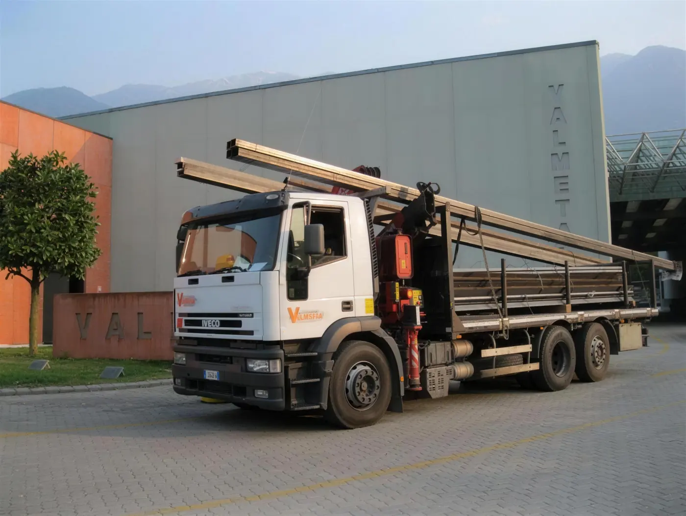 Camion Valmetal con gru carico di travi in acciaio